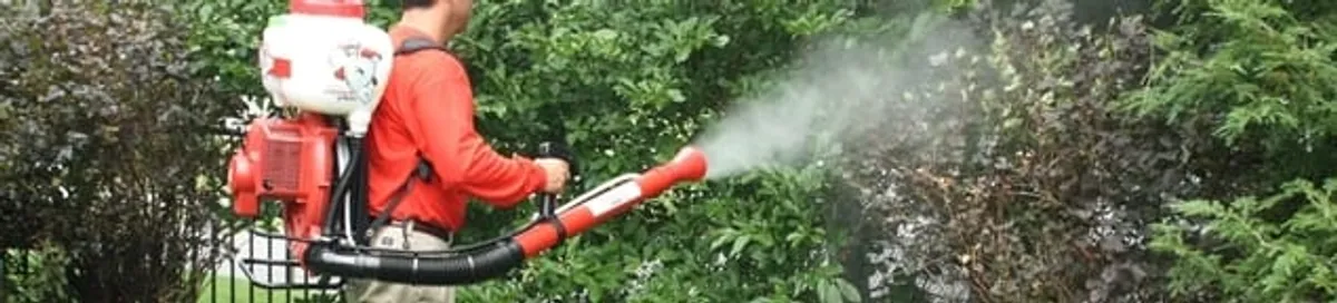 Mosquito control technician fogging shrubs and landscaping for mosquito treatment in Stamford, CT